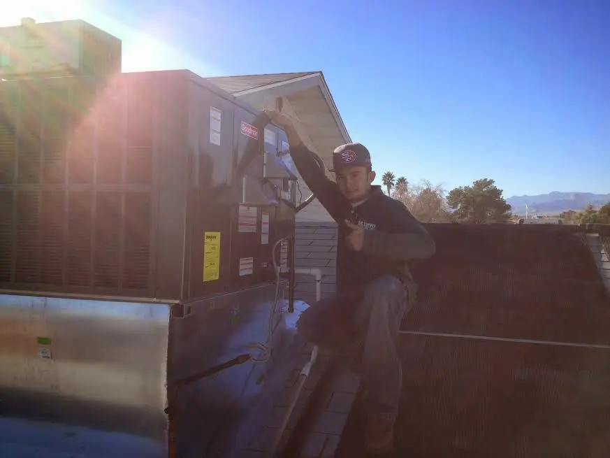 HVAC technician performing Air Duct Repair on a rooftop unit in Medina
